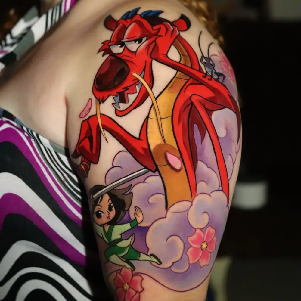 Tatuaje a color del dragón Mushu de Mulan en el brazo